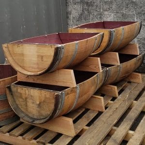Horizontal Flowerbeds made from retired wine barrels stacked for display, you can see the charming wine staining on the inside of the half barrel.